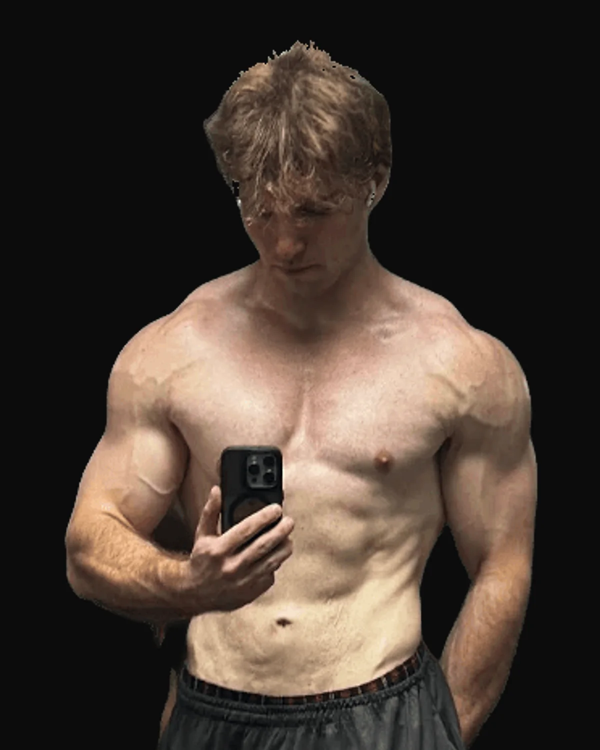 Manuel after years of training, leaner and more muscular, taking a mirror photo