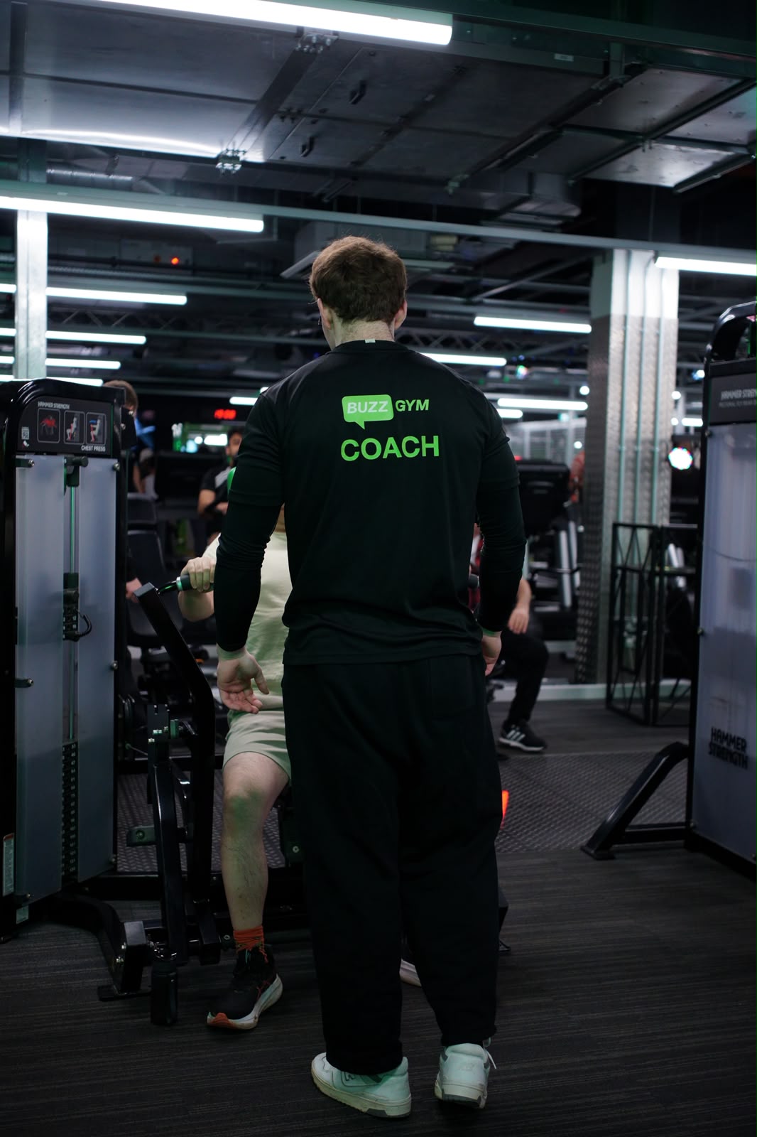 Coaching a client through a chest press, watching the rep from behind the machine