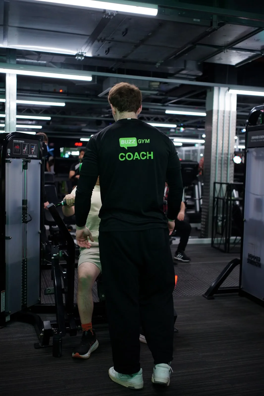 Coaching a client through a chest press, watching the rep from behind the machine