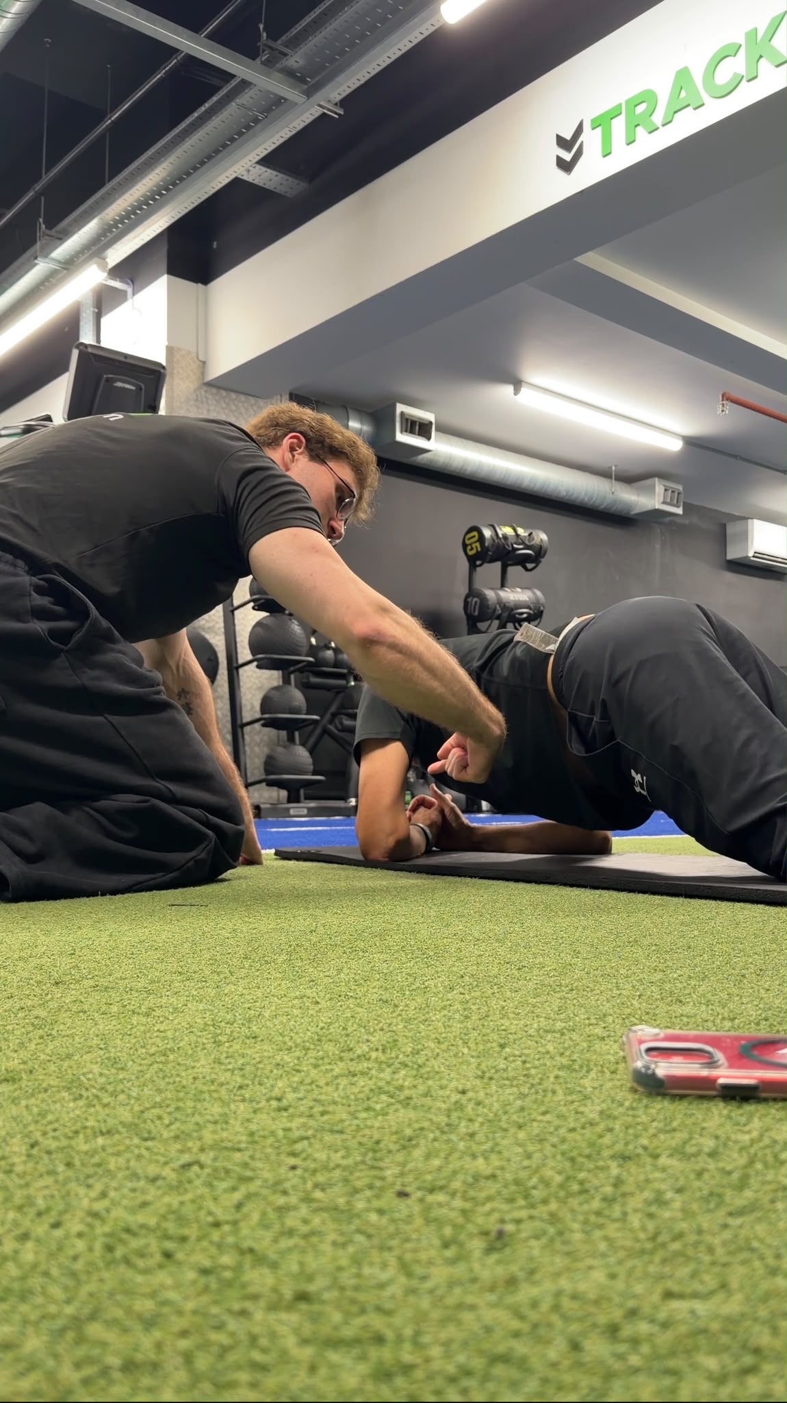 Coaching a client on the floor, setting up position before adding load